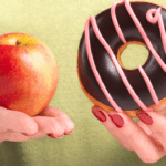 Hands holding red apple and chocolate donut, representing healthy versus unhealthy food choices for children.