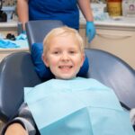 Smiling child sitting comfortably in a dental chair during a pediatric dental checkup