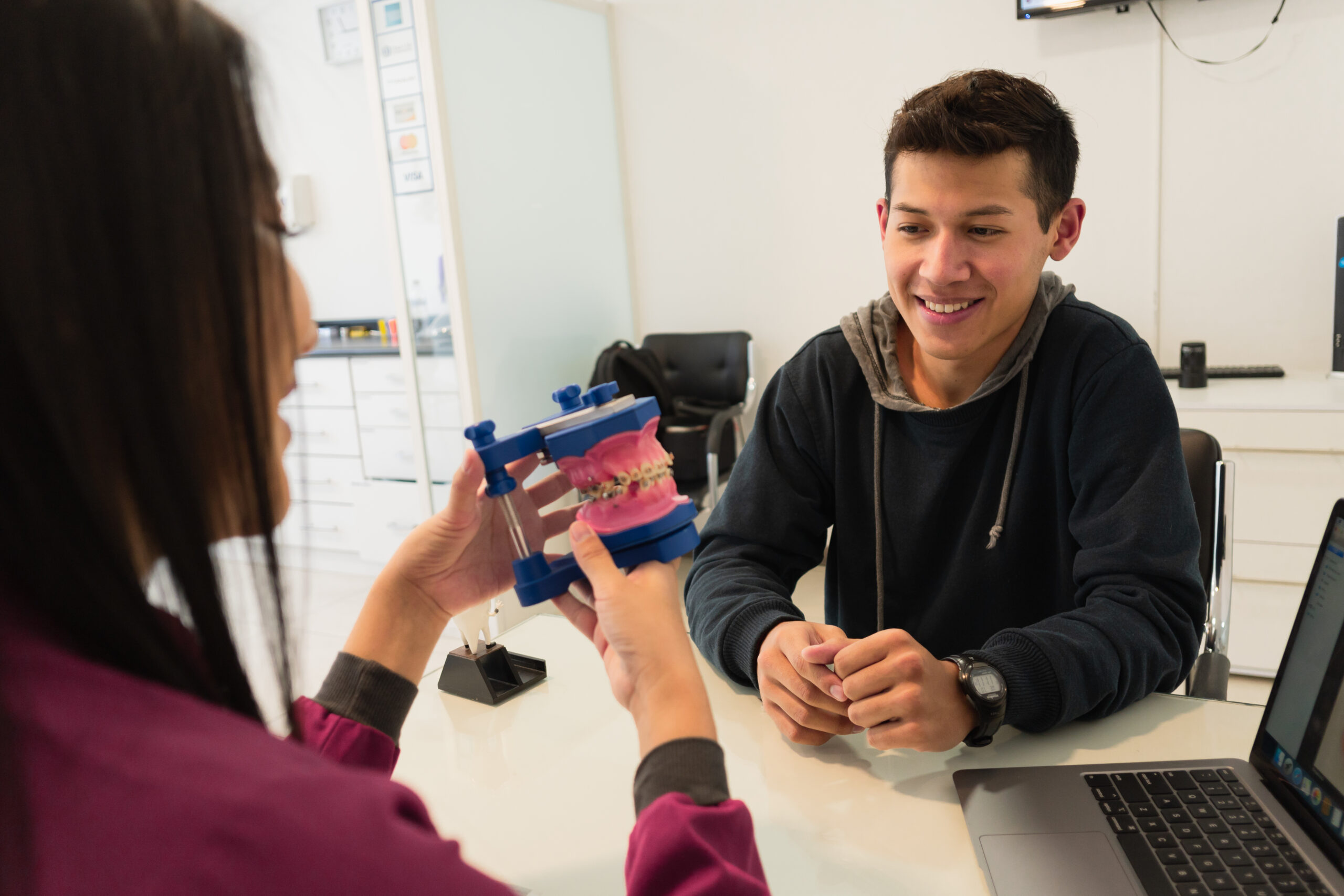 Orthodontist explaining braces treatment options to a teenage patient during a consultation in Spring