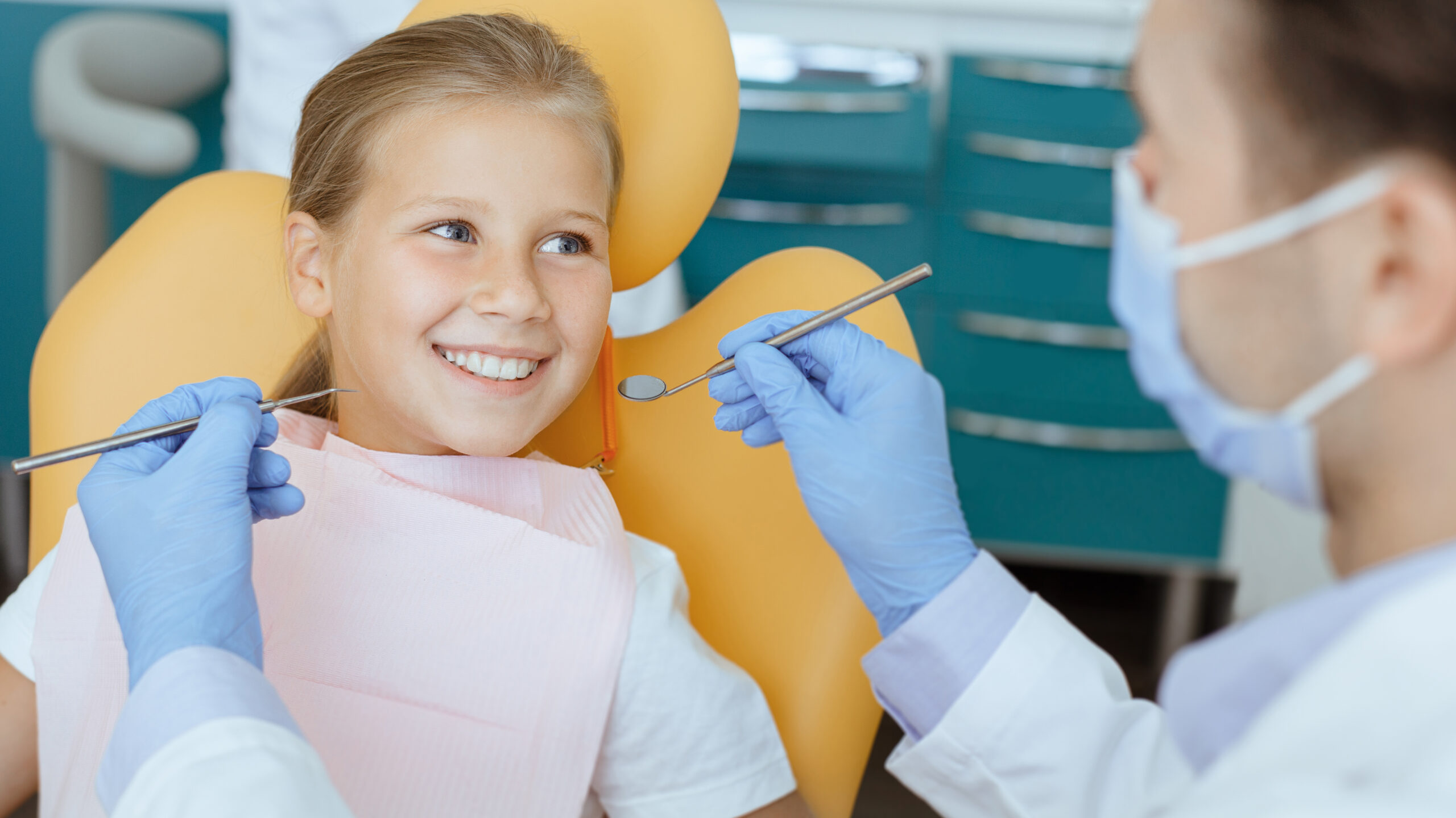Orthodontist examining a young child’s teeth during an early orthodontic evaluation in a dental clinic